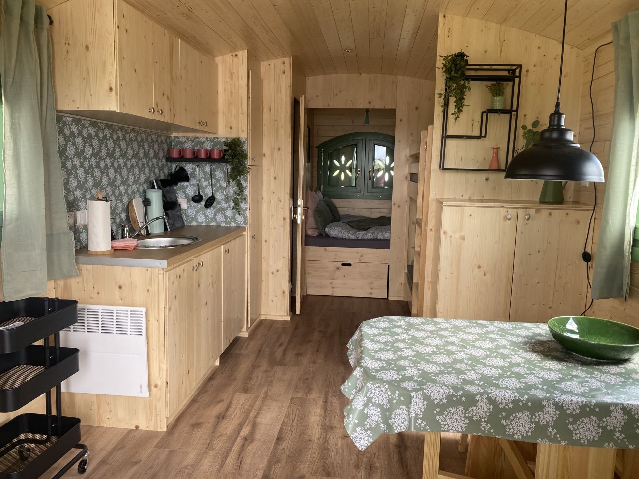 Shepherds wagon equipped with bed, kitchen, and table for rent at Stover Strand campsite near Hamburg. 