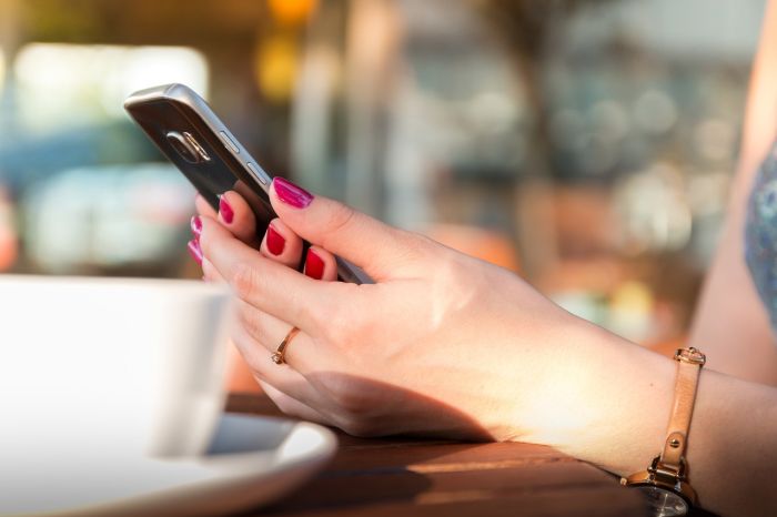 Woman holds smartphone with stover strand guest app
