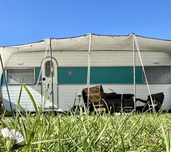 Weiß grüner retro StrandCamper mit Sonnensegel bei Stover Strand Camping