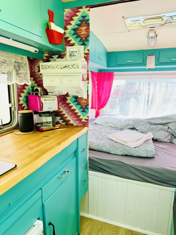 Türkiser Küche und Doppelbett im StrandCamper auf Campingplatz Stover Strand