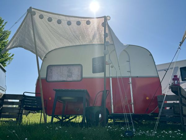 Rot weißer Retro Camper mit Sonnensegel auf dem Elbe Stellplatz Camping Stover Strand