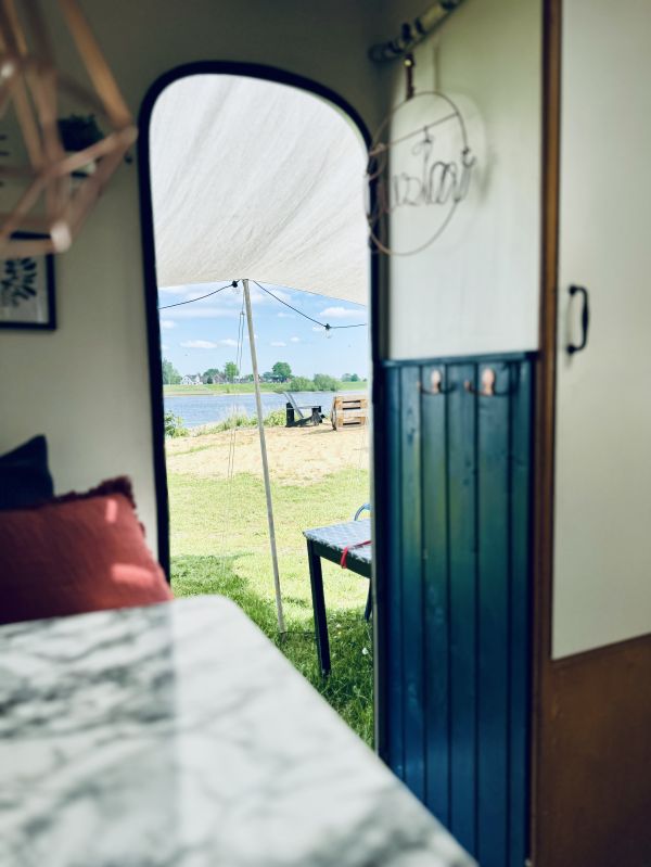 Dunkelblauer Retro Camper mit Blick auf den Stover Strand und die Elbe bei Hamburg