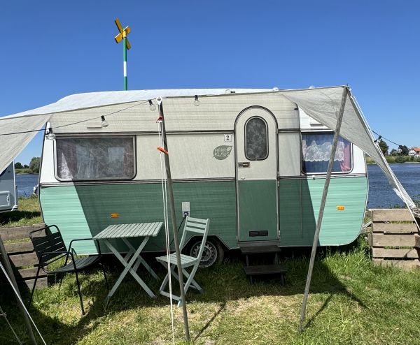 Grüner retro StrandCamper direkt an der Elbe bei Stover Strand Camping nahe Hamburg
