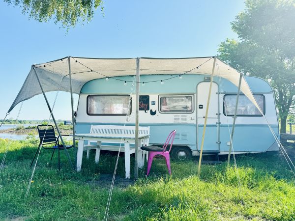 Light blue retro camper right on the Stover Strand Campsite near Hamburg