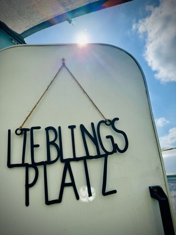 Blue retro camper with a sign "Favorite Spot" at the Stover Strand campsite