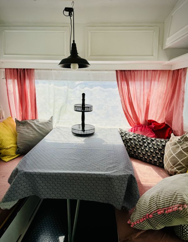 Blue retro camper with indoor sitting area overlooking Stover Strand camping