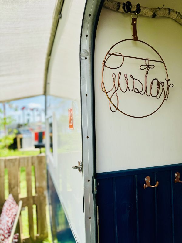 Dark blue retro camper with name tag at the Stover Strand campsite near Hamburg