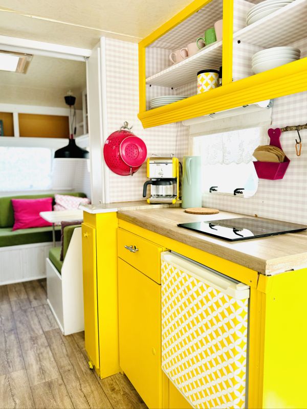 Retro camper Petronella Citronella furnished with a bright yellow kitchen and complete equipment at the Stover Strand campsite near Hamburg