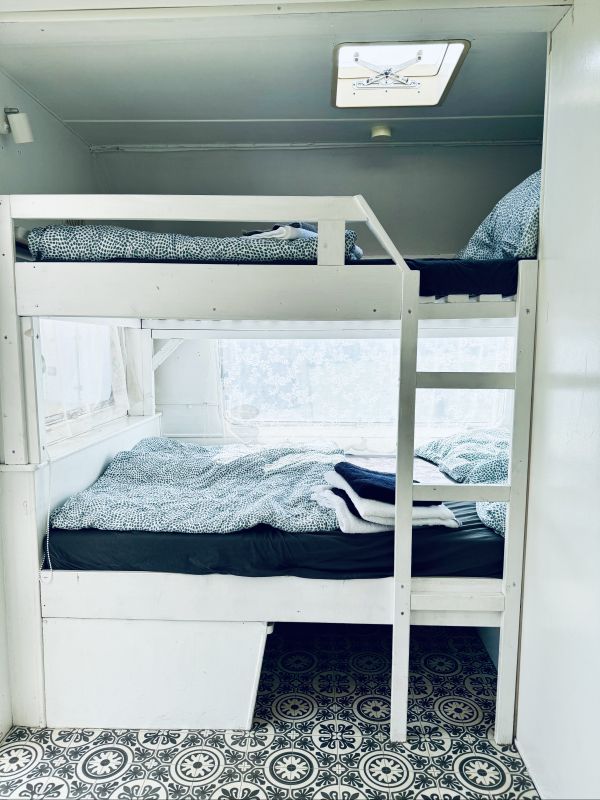 White turquoise retro camper with bunk double bed right on Stover Strand Camping