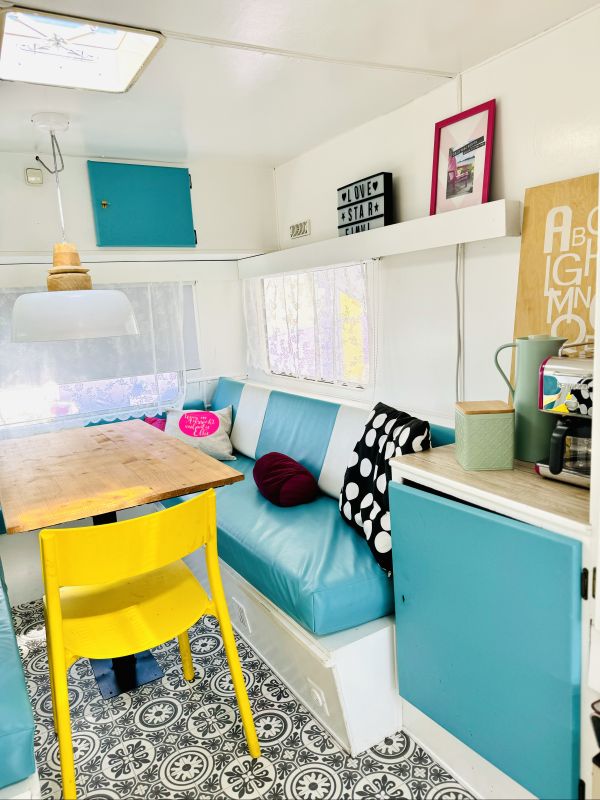 Retro camper with a large, colorful sitting area in turquoise at Stover Strand Camping