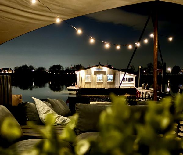 Hausboot & Beachclub mit Pflanzen und Möbeln am Stover Strand Campingplatz Hamburg nah