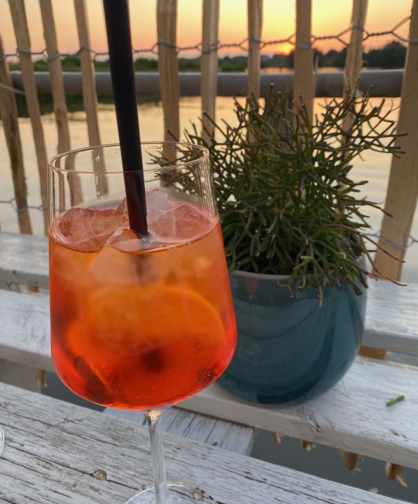 Leckerer Aperol bei Sonnenuntergang über der Elbe auf dem Hausboot am Stover Strand