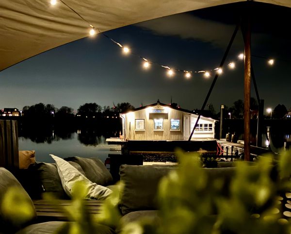 Beachclub with fairy lights and pallet furniture in the evening at Stover Strand