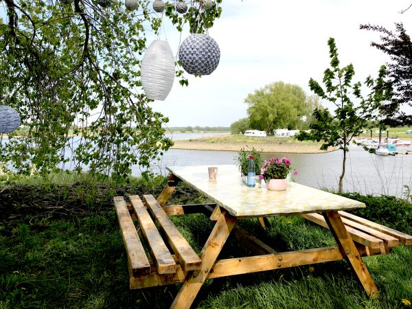 Sitzbank am Fluss auf dem Campingplatz Stover Strand an der Elbe bei Hamburg