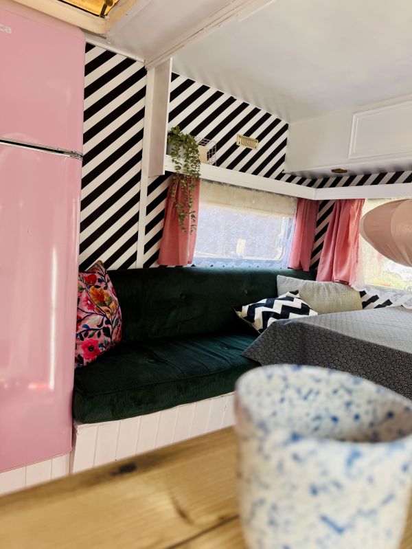 Sitzecke mit Kissen und rosa Gardinen im Stover StrandCamper an der Elbe